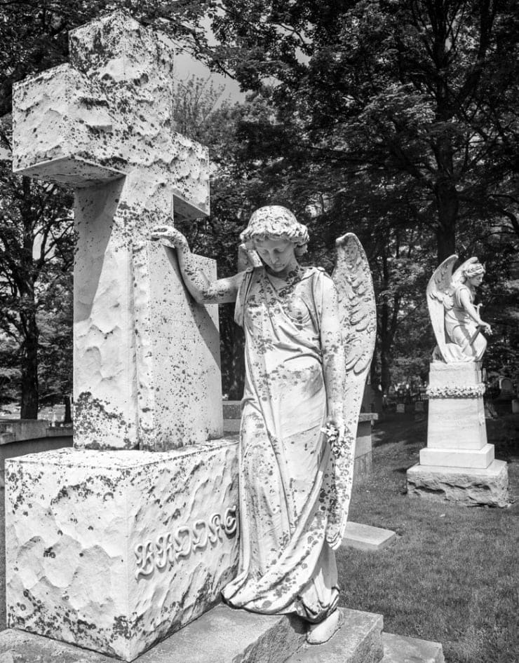 Two marble angels fill the frame in a Belfast Maine cemetery.